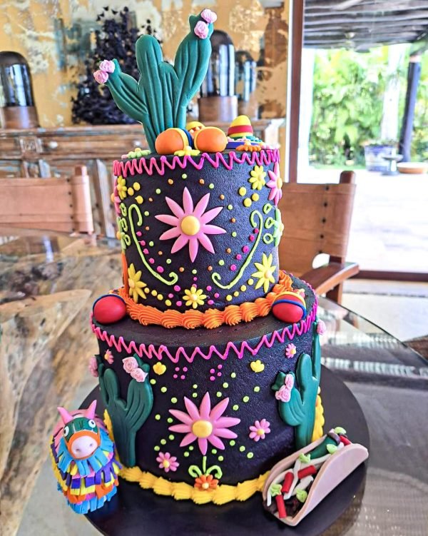 Pastel de cumpleaños mexicano con fondo negro y decoración colorida