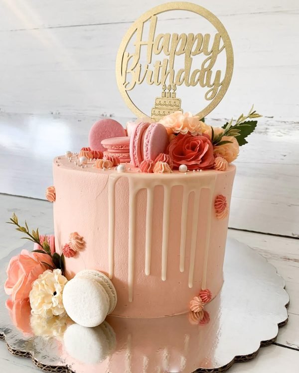 Pasteles de cumpleaños con macarrons y flores en color rosa